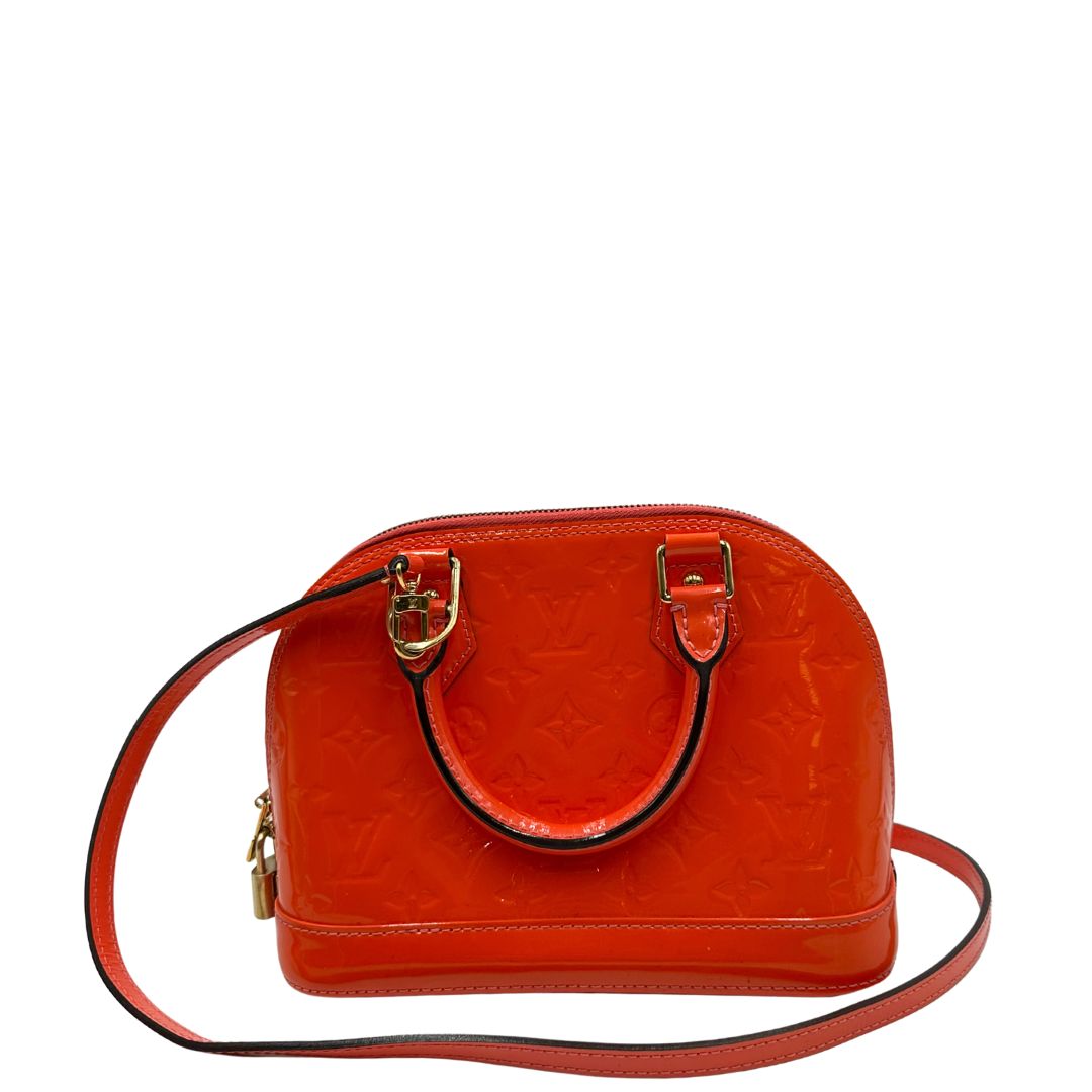 retro Borsa Louis Vuitton Alma BB in pelle Vernis arancione corallo monogram e parti metalliche dorate. Munita di doppi manici stondati e una tracolla amovibile, dotata di clochette porta chiavi. Completa di dustbag, lucchetto e chiavi, di lusso, originale, ottime condizioni, usata. 