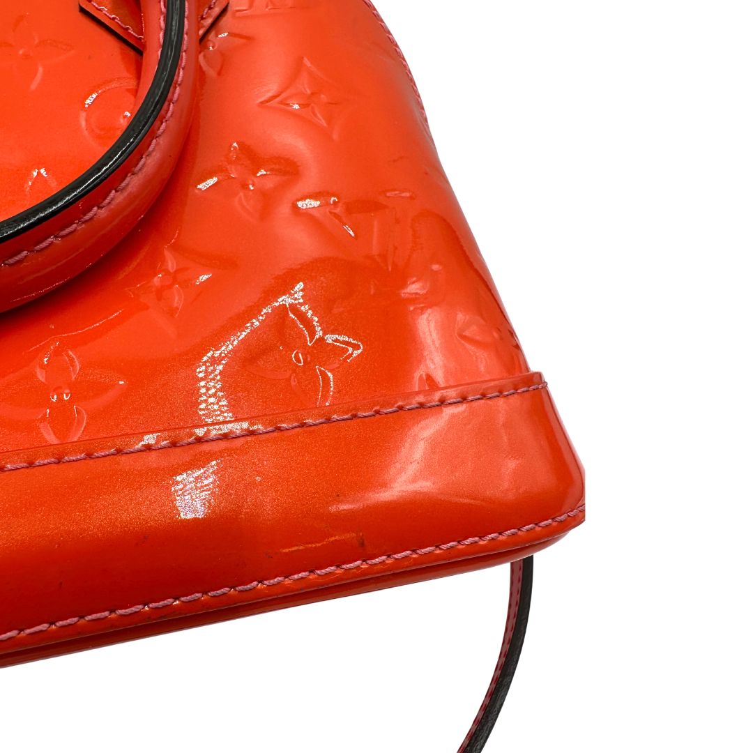 angolo Borsa Louis Vuitton Alma BB in pelle Vernis arancione corallo monogram e parti metalliche dorate. Munita di doppi manici stondati e una tracolla amovibile, dotata di clochette porta chiavi. Completa di dustbag, lucchetto e chiavi, di lusso, originale, ottime condizioni, usata. 
