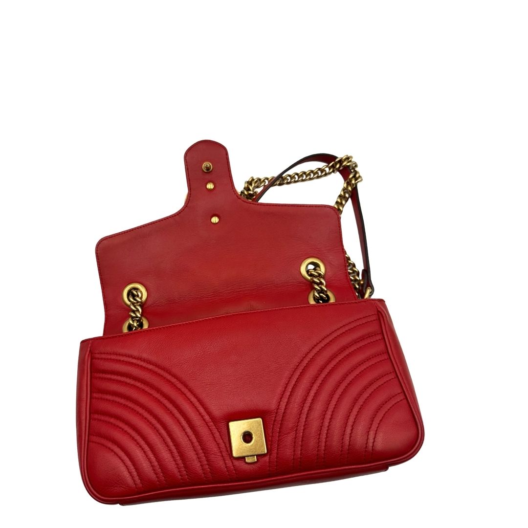 Borsa Gucci Marmont in pelle matelassé rossa con tracolla scorrevole in catena e spallaccio in pelle, rifinita con parti metalliche dorate. Completa di dustbag. Originale, usato, di lusso, in ottime condizioni.