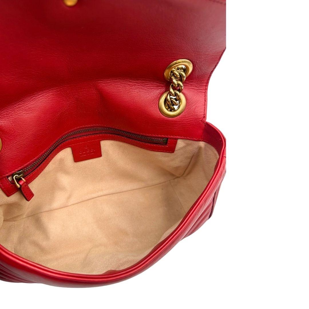 Interno di una Borsa Gucci Marmont in pelle matelassé rossa con tracolla scorrevole in catena e spallaccio in pelle, rifinita con parti metalliche dorate. Completa di dustbag. Originale, usato, di lusso, in ottime condizioni.