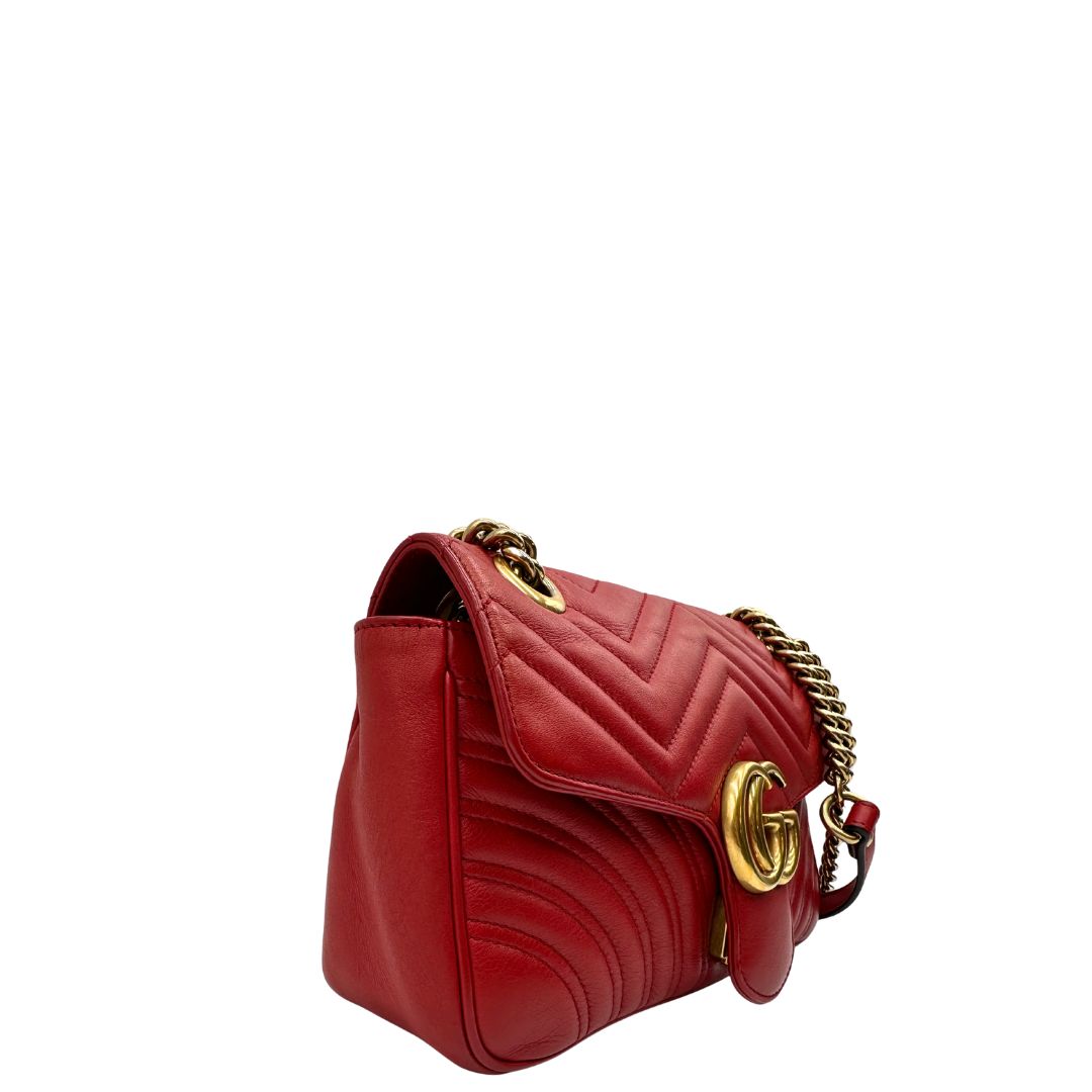 Lato destro di una Borsa Gucci Marmont in pelle matelassé rossa con tracolla scorrevole in catena e spallaccio in pelle, rifinita con parti metalliche dorate. Completa di dustbag. Originale, usato, di lusso, in ottime condizioni.