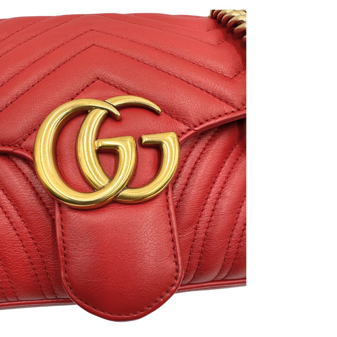 Chiusura di una Borsa Gucci Marmont in pelle matelassé rossa con tracolla scorrevole in catena e spallaccio in pelle, rifinita con parti metalliche dorate. Completa di dustbag. Originale, usato, di lusso, in ottime condizioni.