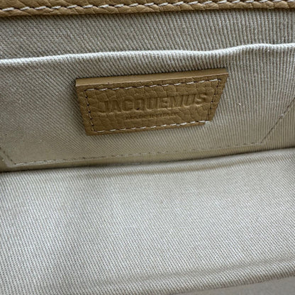 interno Borsa Jacquemus in pelle martellata color cammello con parti metalliche dorate; munita di un manico singolo e una tracolla amovibile e regolabile. Completa di dustbag, di lusso, originale, ottime condizioni, usata. 