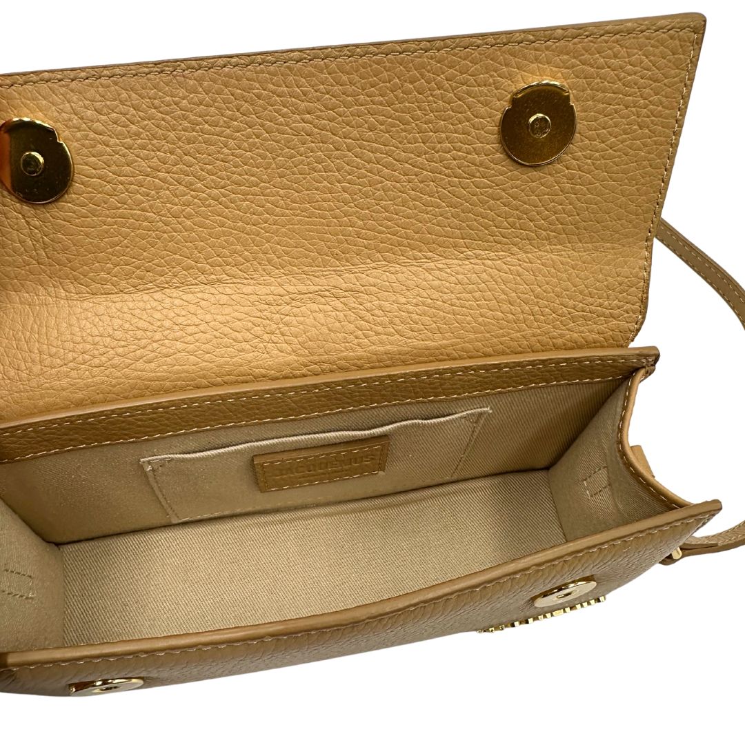 interno Borsa Jacquemus in pelle martellata color cammello con parti metalliche dorate; munita di un manico singolo e una tracolla amovibile e regolabile. Completa di dustbag, di lusso, originale, ottime condizioni, usata. 