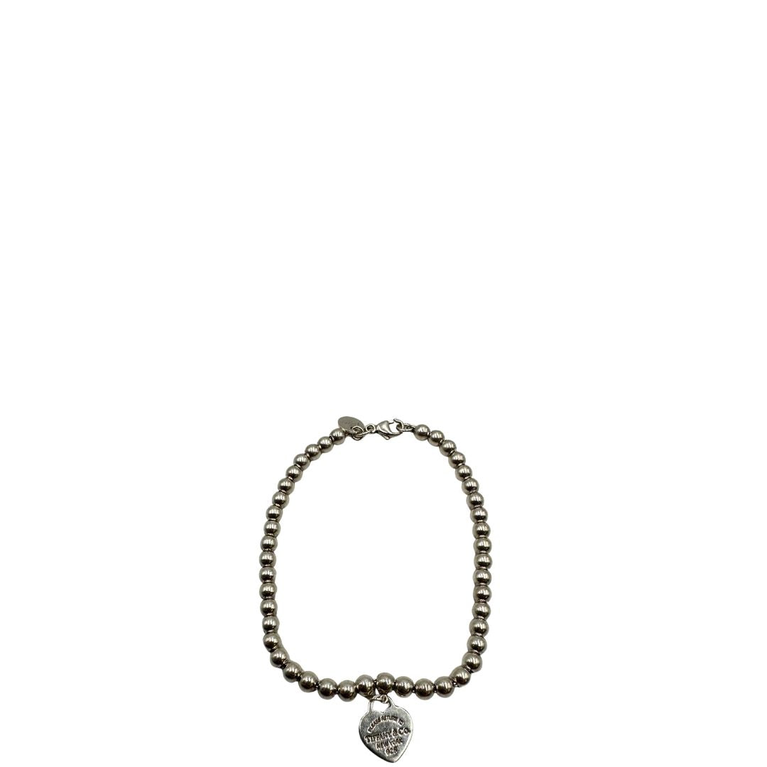 Bracciale Tiffany&Co. della collezione Return to Tiffany in argento 925 composto da sfere circolari e ciondolo cuore smaltato in verde Tiffany. Completo di scatola e sacchetto anti polvere.