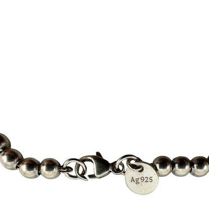 Bracciale Tiffany&Co. della collezione Return to Tiffany in argento 925 composto da sfere circolari e ciondolo cuore smaltato in verde Tiffany. Completo di scatola e sacchetto anti polvere.