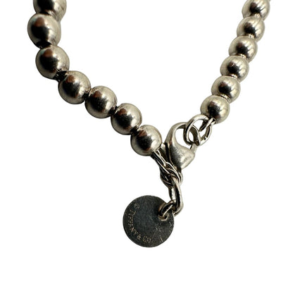 Bracciale Tiffany&Co. della collezione Return to Tiffany in argento 925 composto da sfere circolari e ciondolo cuore smaltato in verde Tiffany. Completo di scatola e sacchetto anti polvere.