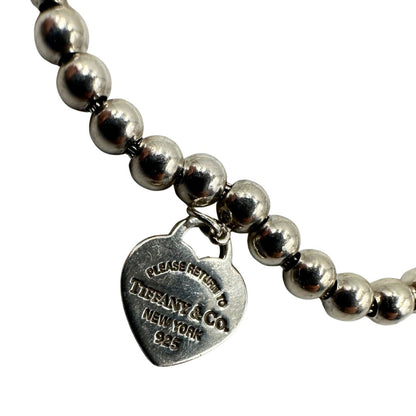 Bracciale Tiffany&Co. della collezione Return to Tiffany in argento 925 composto da sfere circolari e ciondolo cuore smaltato in verde Tiffany. Completo di scatola e sacchetto anti polvere.