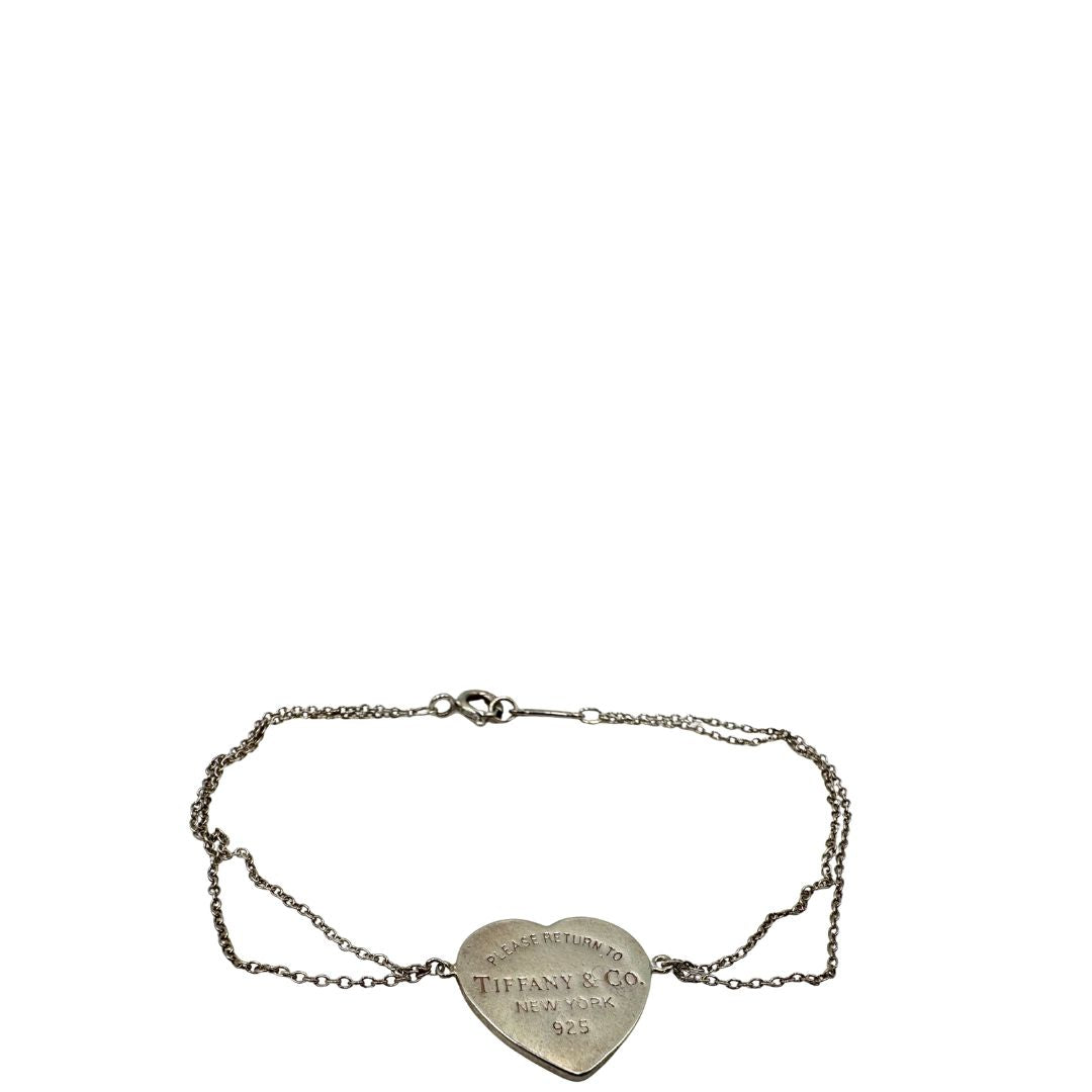 Bracciale Tiffany&Co. in argento 925, caratterizzato da una doppia catenina sottile e dal celebre cuore inciso “Please Return to Tiffany&Co. New York 925”. Munito di busta e sacchetto anti polvere.