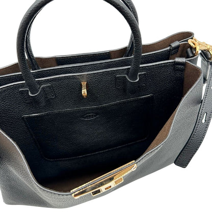 Interno di una borsa Tod's in pelle nera martellata, con parti metalliche dorate; munita di manici stondati e di una tracolla regolabile ed amovibile. Completa di dustbag.