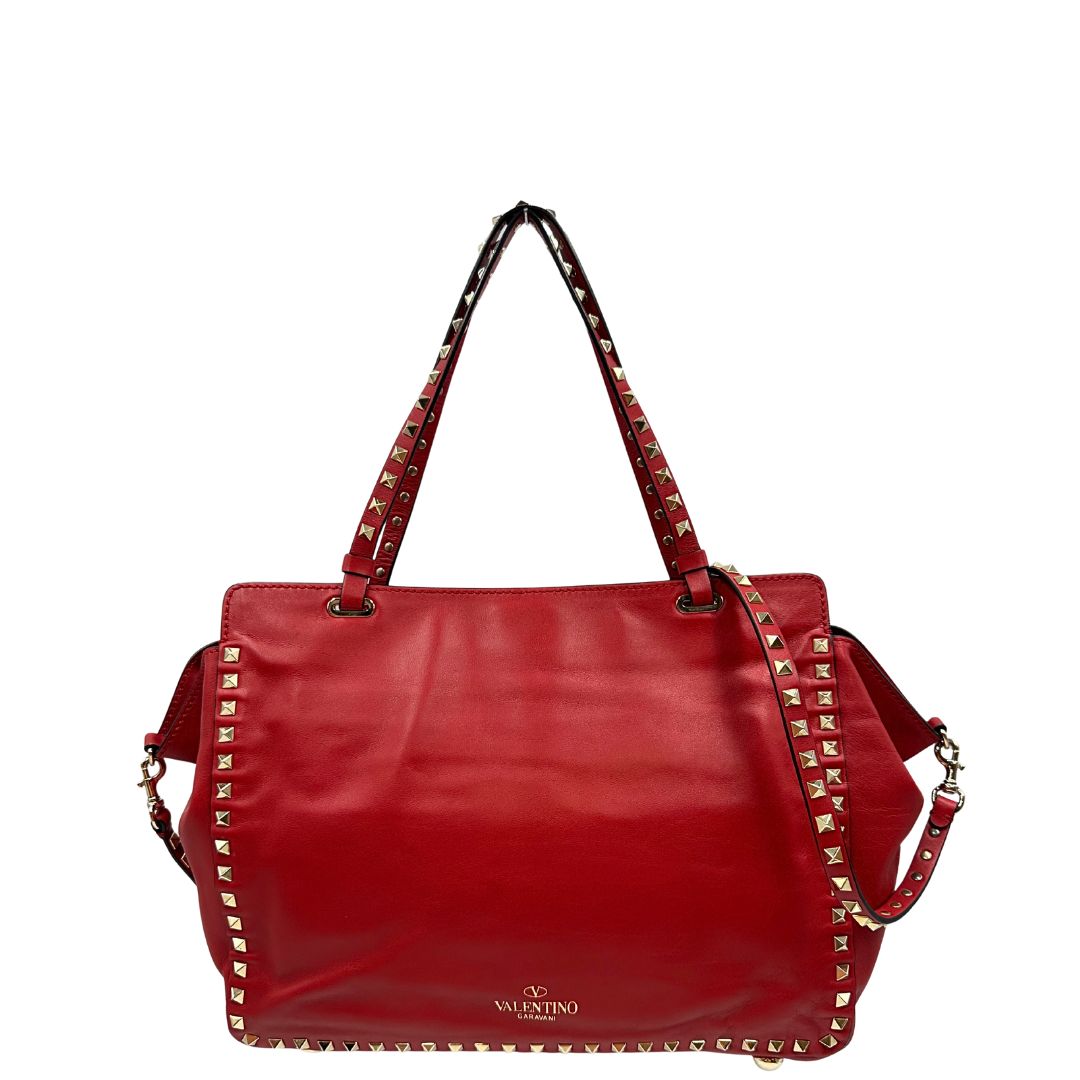 Retro di una borsa Valentino Garavani in pelle rossa con parti metalliche dorate; impreziosita da borchie piramidali e munita di doppi manici e tracolla amovibile. Completa di dustbag. 