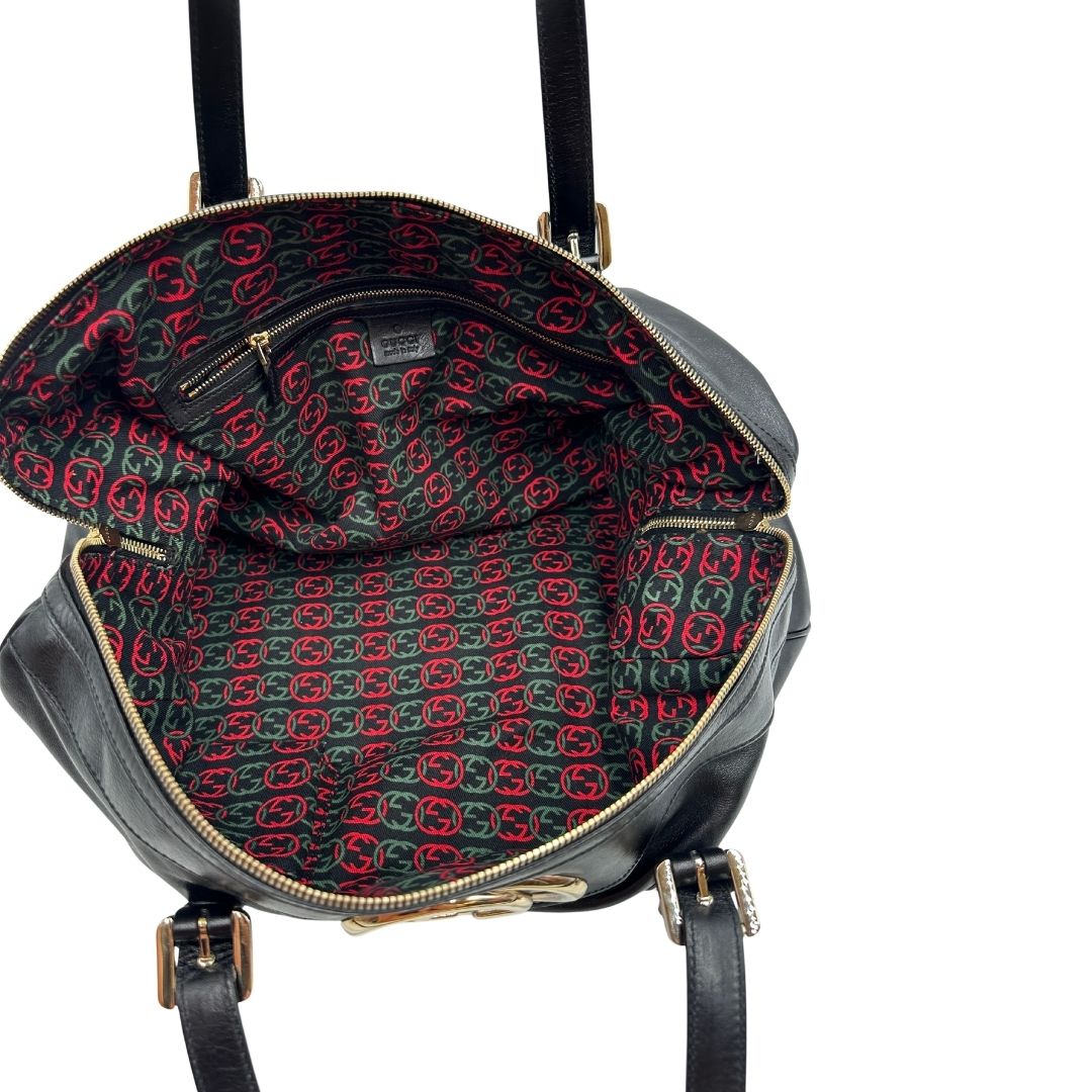 Interno di una Bauletto Gucci Britt Boston in pelle nera con parti metalliche dorate e doppi manici; da indossare a spalla. Rifinita con doppie G incrociate in metallo sul front. Completa di dustbag. Originale, usata, di lusso, in ottime condizioni.