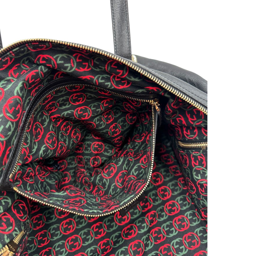 Tasca interna di una Bauletto Gucci Britt Boston in pelle nera con parti metalliche dorate e doppi manici; da indossare a spalla. Rifinita con doppie G incrociate in metallo sul front. Completa di dustbag. Originale, usata, di lusso, in ottime condizioni.