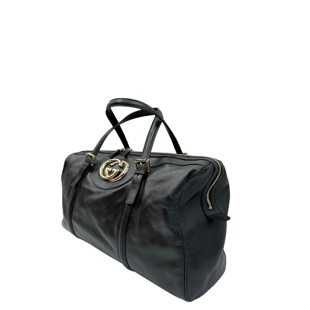 Lato sinistro di una Bauletto Gucci Britt Boston in pelle nera con parti metalliche dorate e doppi manici; da indossare a spalla. Rifinita con doppie G incrociate in metallo sul front. Completa di dustbag. Originale, usata, di lusso, in ottime condizioni.