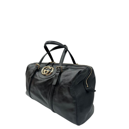 Lato sinistro di una Bauletto Gucci Britt Boston in pelle nera con parti metalliche dorate e doppi manici; da indossare a spalla. Rifinita con doppie G incrociate in metallo sul front. Completa di dustbag. Originale, usata, di lusso, in ottime condizioni.