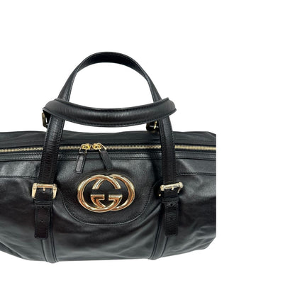 Manici di una Bauletto Gucci Britt Boston in pelle nera con parti metalliche dorate e doppi manici; da indossare a spalla. Rifinita con doppie G incrociate in metallo sul front. Completa di dustbag. Originale, usata, di lusso, in ottime condizioni.