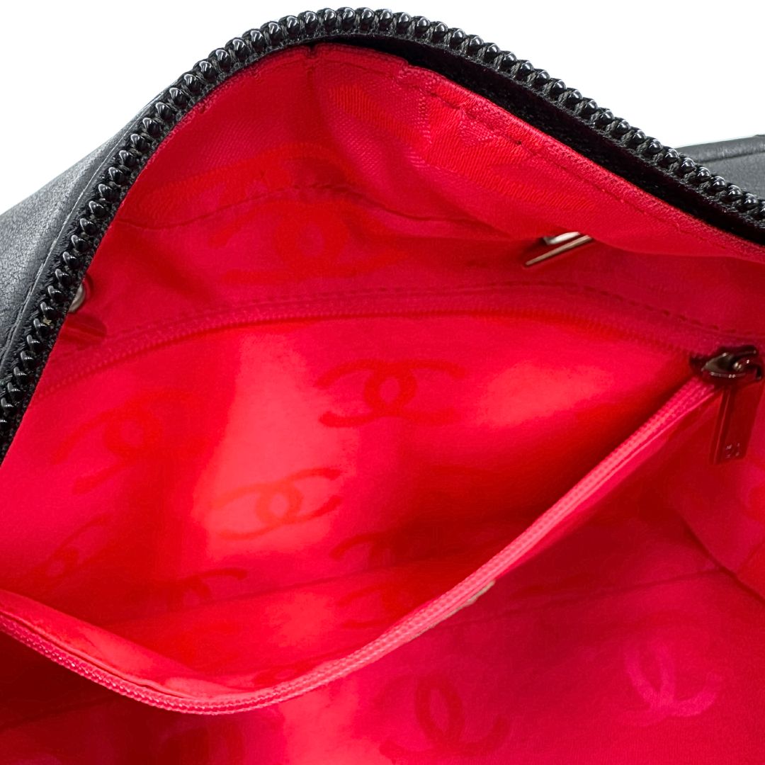 Interno di una borsa Cambon Reporter Chanel in pelle trapuntata nera e doppie C bianche sul front, con tasche per accessori e doppi manici medio lunghi, rifinita con parti metalliche argentate. Completa di dustbag e card d'autenticità. Indossabile a spalla.