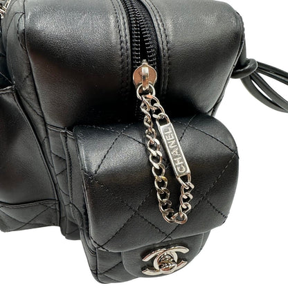 Dettagli metallici di una borsa Cambon Reporter Chanel in pelle trapuntata nera e doppie C bianche sul front, con tasche per accessori e doppi manici medio lunghi, rifinita con parti metalliche argentate. Completa di dustbag e card d'autenticità. Indossabile a spalla.