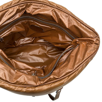 Interno di una borsa Moncler in poliuretano color caramello effetto imbottito e finiture in pelle tono su tono, con metalleria dorata. Munita di cartellino. Da indossare a spalla.