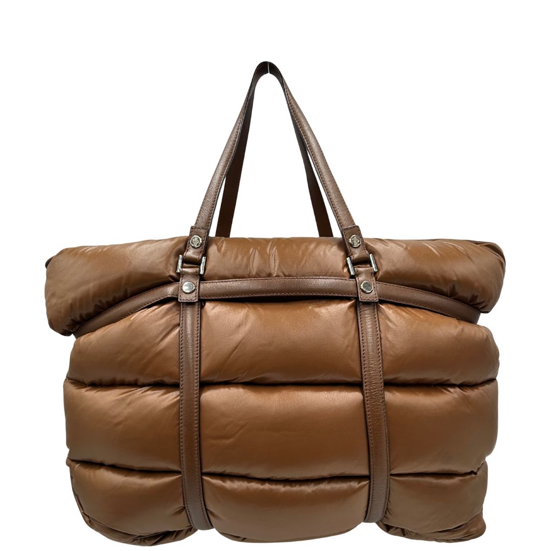 Retro di una borsa Moncler in poliuretano color caramello effetto imbottito e finiture in pelle tono su tono, con metalleria dorata. Munita di cartellino. Da indossare a spalla.