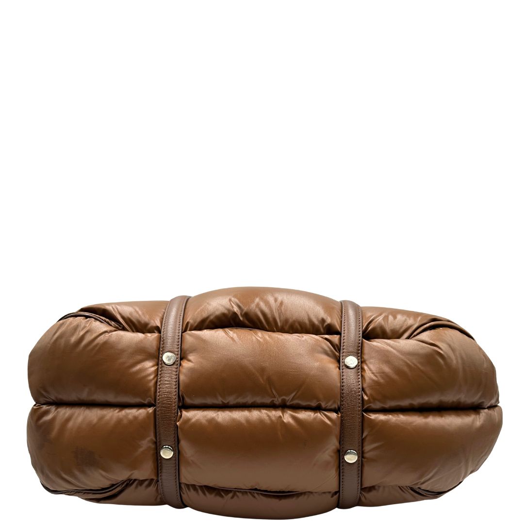 Base di una borsa Moncler in poliuretano color caramello effetto imbottito e finiture in pelle tono su tono, con metalleria dorata. Munita di cartellino. Da indossare a spalla.