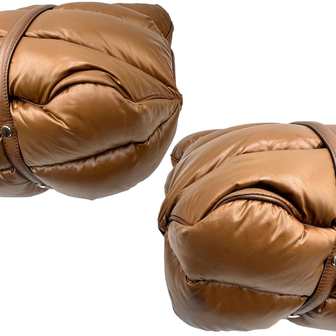 Angoli di una borsa Moncler in poliuretano color caramello effetto imbottito e finiture in pelle tono su tono, con metalleria dorata. Munita di cartellino. Da indossare a spalla.