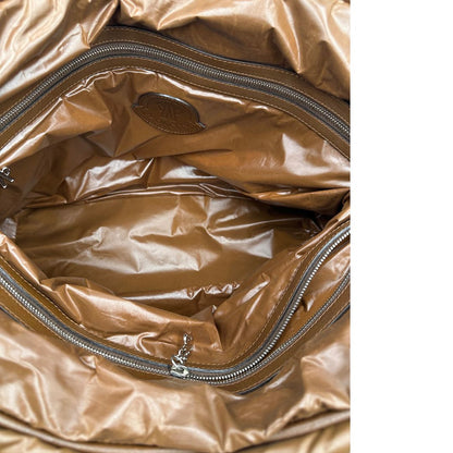 Interno di una borsa Moncler in poliuretano color caramello effetto imbottito e finiture in pelle tono su tono, con metalleria dorata. Munita di cartellino. Da indossare a spalla.