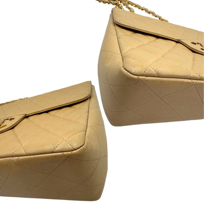Angoli di una borsa Chanel in pelle beige matelassè e parti metalliche dorate; munita di una tracolla scorrevole in catena e pelle. Indossabile a spalla e a tracolla. Completa di scatola, dustbag e card d'autenticità.