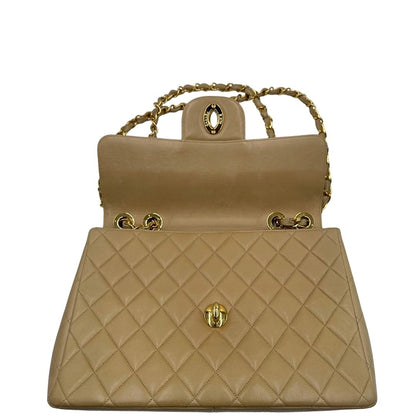 Angoli di una borsa Chanel in pelle beige matelassè e parti metalliche dorate; munita di una tracolla scorrevole in catena e pelle. Indossabile a spalla e a tracolla. Completa di scatola, dustbag e card d'autenticità.