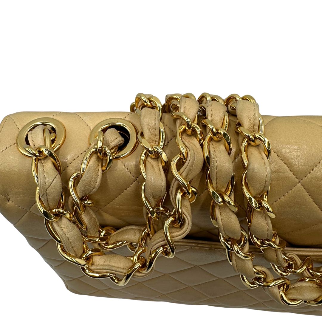 Dettaglio tracolla di una borsa Chanel in pelle beige matelassè e parti metalliche dorate; munita di una tracolla scorrevole in catena e pelle. Indossabile a spalla e a tracolla. Completa di scatola, dustbag e card d'autenticità.