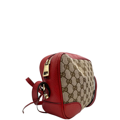 Lato destro di una Borsa Gucci in tessuto GG beige con finiture in pelle martellata rossa e parti metalliche dorate; munita di una tracoll regolabile. Completa di dustbag. Originale, usata, di lusso, in ottime condizioni.