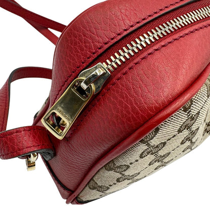 Borsa Gucci in tessuto GG beige con finiture in pelle martellata rossa e parti metalliche dorate; munita di una tracoll regolabile. Completa di dustbag. Originale, usata, di lusso, in ottime condizioni.