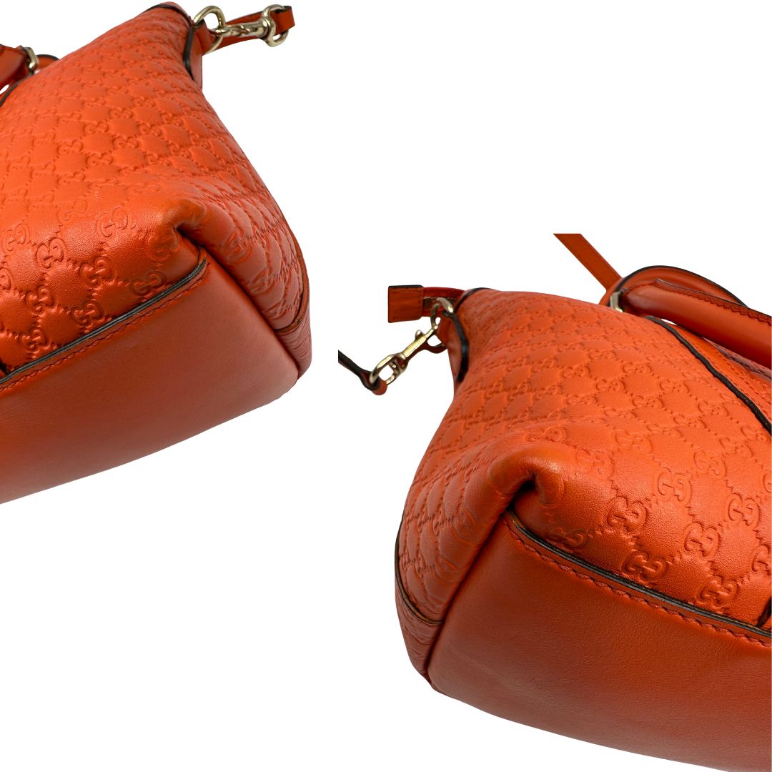 Angoli di una borsa Gucci in pelle arancione GG con parti metalliche dorate; munita di doppi manici e una tracolla amovibile e regolabile.