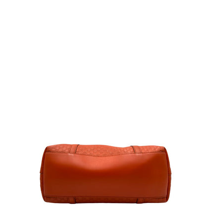 Base di una borsa Gucci in pelle arancione GG con parti metalliche dorate; munita di doppi manici e una tracolla amovibile e regolabile.