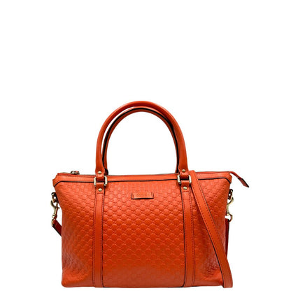 Front di una borsa Gucci in pelle arancione GG con parti metalliche dorate; munita di doppi manici e una tracolla amovibile e regolabile.