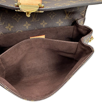 Interno di una borsa Louis Vuitton Métis in canvas marrone monogram con dettagli in vacchetta naturale e parti metalliche dorate. Munita di un manico singolo e una tracolla regolabile e amovibile. Dotata di scatola.