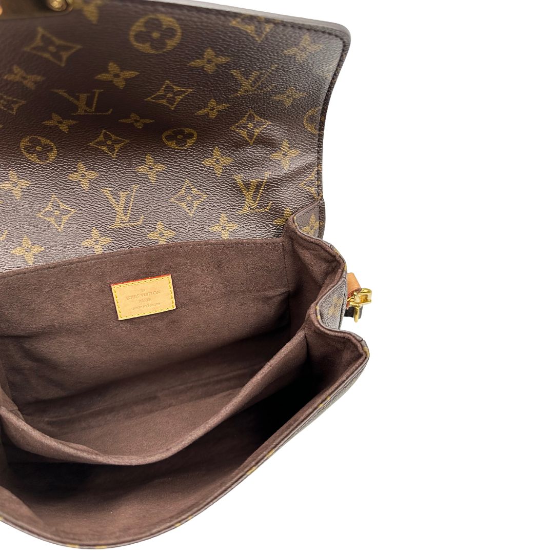 Interno di una borsa Louis Vuitton Métis in canvas marrone monogram con dettagli in vacchetta naturale e parti metalliche dorate. Munita di un manico singolo e una tracolla regolabile e amovibile. Dotata di scatola.
