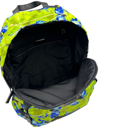 Interno di uno zaino Prada Radar in nylon tecnico con chiusura a zip. Design caratterizzato da stampa grafica multicolor effetto radar. Struttura con ampio scomparto principale, tasca frontale a zip e tasca interna con zip. Spallacci regolabili con imbottitura e pannello posteriore traspirante in mesh per un maggiore comfort. Manico superiore in pelle nera saffiano. Dettagli con logo triangolo Prada smaltato applicato sul fronte.