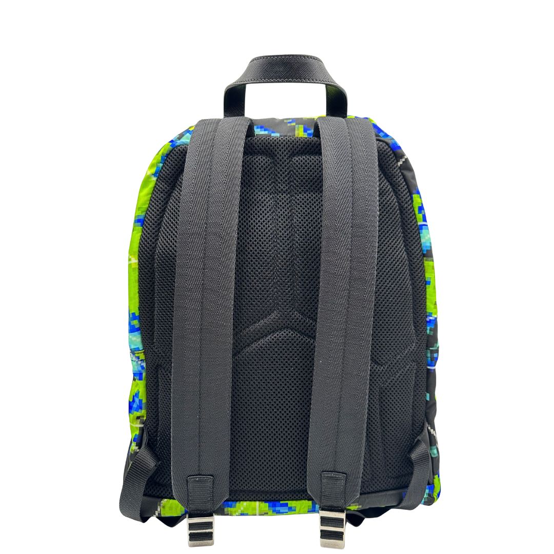 Retro di uno zaino Prada Radar in nylon tecnico con chiusura a zip. Design caratterizzato da stampa grafica multicolor effetto radar. Struttura con ampio scomparto principale, tasca frontale a zip e tasca interna con zip. Spallacci regolabili con imbottitura e pannello posteriore traspirante in mesh per un maggiore comfort. Manico superiore in pelle nera saffiano. Dettagli con logo triangolo Prada smaltato applicato sul fronte.