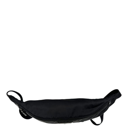Vista superiore di un marsupio Prada in Re-Nylon nero con dettagli in pelle tono su tono, logo gommato sul front e parti in metallo argentato. Leggermente regolabile, indossabile a marsupio o cross body.