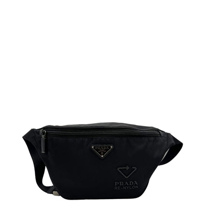 Front di un marsupio Prada in Re-Nylon nero con dettagli in pelle tono su tono, logo gommato sul front e parti in metallo argentato. Leggermente regolabile, indossabile a marsupio o cross body.