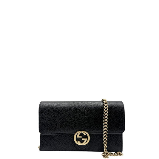 Front di una borsa Gucci Interlocking in pelle martellata nera con parti metalliche oro chiaro. Munita di una tracolla amovibile in catena e spallaccio in pelle. Chiusura con doppie G incrociate. Completa di scatola e dustbag. Indossabile a tracolla.