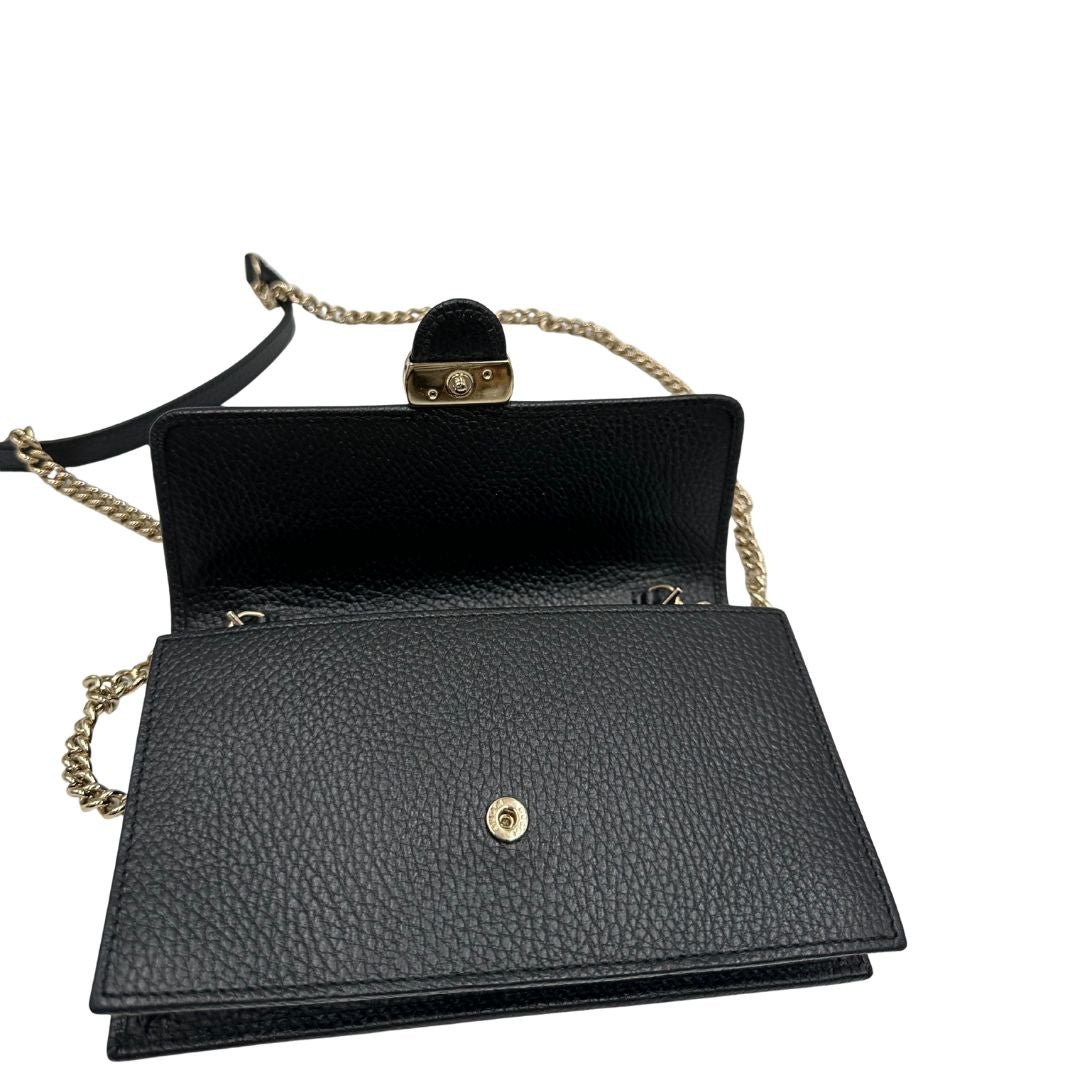 Apertura di una borsa Gucci Interlocking in pelle martellata nera con parti metalliche oro chiaro. Munita di una tracolla amovibile in catena e spallaccio in pelle. Chiusura con doppie G incrociate. Completa di scatola e dustbag. Indossabile a tracolla.