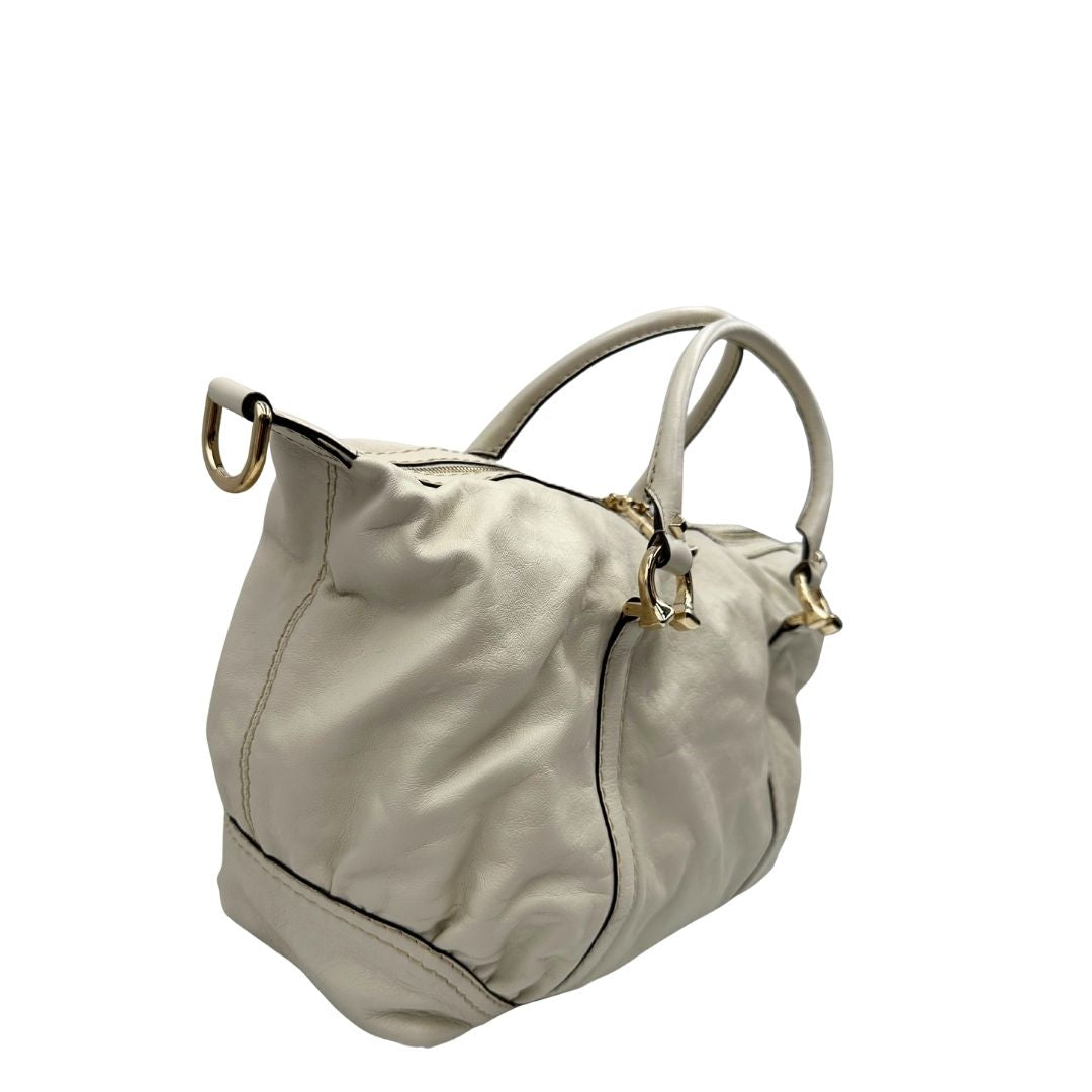 Lato destro di un Bauletto Gucci in pelle bianco avorio parti metalliche dorate, munita di due manici stondati. Indossabile a mano. Originale, usato, di lusso, in ottime condizioni.