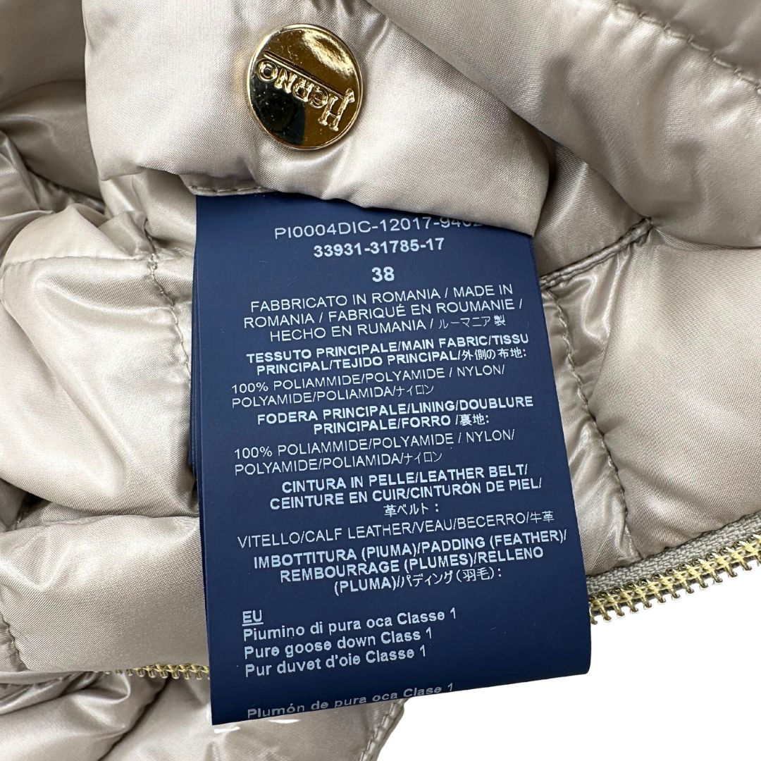 Piumino Herno in 100% poliammide color champagne. Maniche a 3/4 e parti metalliche dorate.