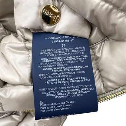 Piumino Herno in 100% poliammide color champagne. Maniche a 3/4 e parti metalliche dorate.