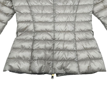 Piumino Herno in 100% poliammide color champagne. Maniche a 3/4 e parti metalliche dorate.