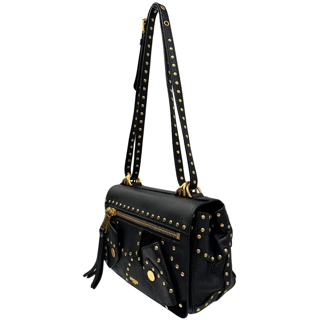 Lato sinistro di una Borsa Moschino in pelle nera con inserti metallici dorati, arricchita da borchie dorate, zip frontale con maxi tirazip e applicazioni geometriche. munita di una tracolla regolabile non amovibile. Completa di Card d'autenticità Misure. Originale, Usata, di lusso, in ottime condizioni.