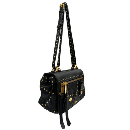 Lato destro di una Borsa Moschino in pelle nera con inserti metallici dorati, arricchita da borchie dorate, zip frontale con maxi tirazip e applicazioni geometriche. munita di una tracolla regolabile non amovibile. Completa di Card d'autenticità Misure. Originale, Usata, di lusso, in ottime condizioni.