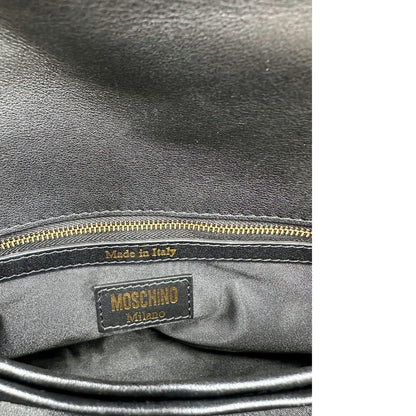 Interno di una Borsa Moschino in pelle nera con inserti metallici dorati, arricchita da borchie dorate, zip frontale con maxi tirazip e applicazioni geometriche. munita di una tracolla regolabile non amovibile. Completa di Card d'autenticità Misure. Originale, Usata, di lusso, in ottime condizioni.
